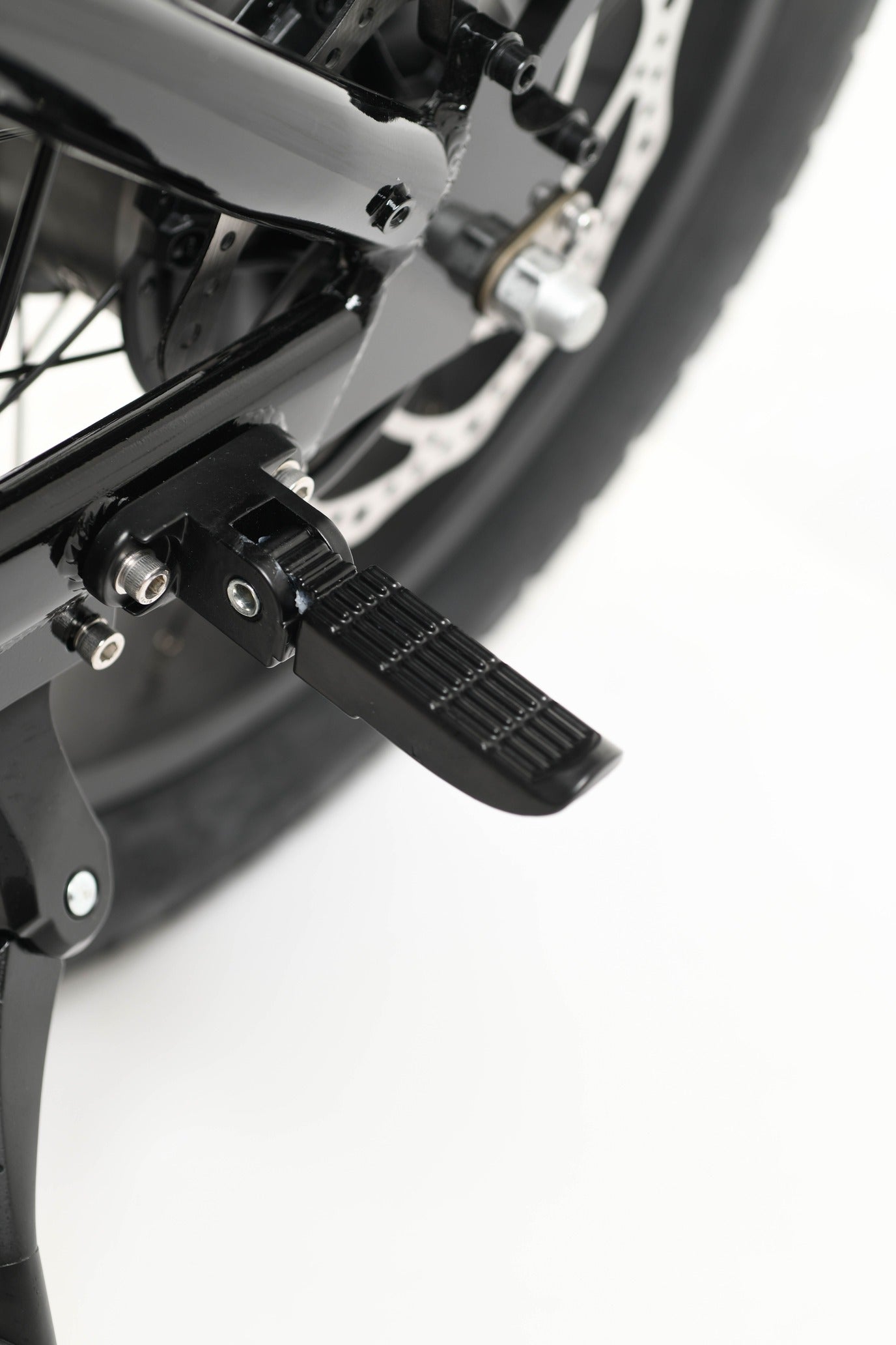 Close-up of a electric bike foot peg on a white background