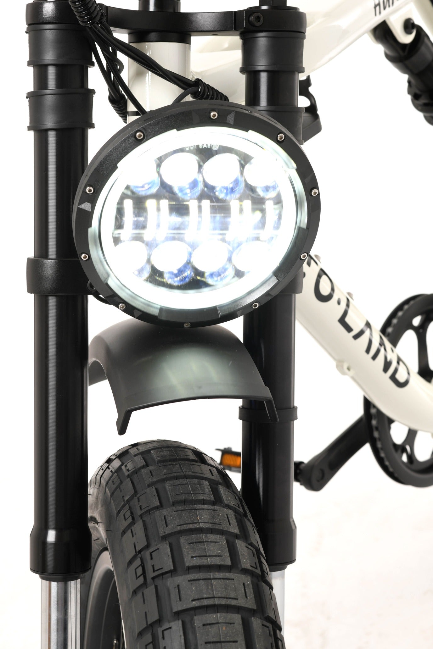 Close-up of a bicycle headlight with 'ToLand' branding on a white background