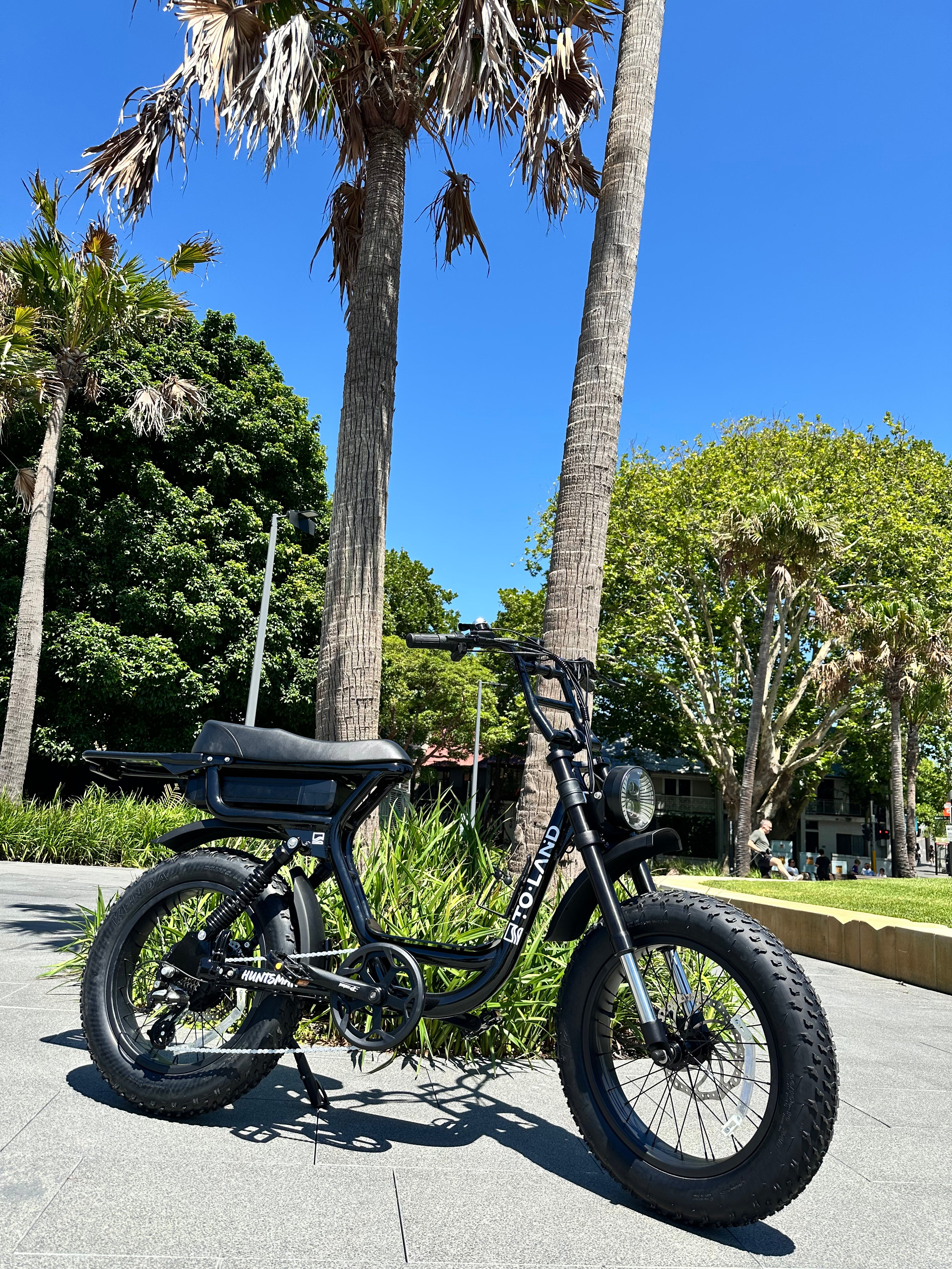 An electric bike with a step-through frame, equipped with a 500W motor and a 48V 15Ah battery, featuring a black color scheme, hydraulic disc brakes, and LED front light. Accessories such as a helmet, chain lock, phone holder, and top bar bag are included.